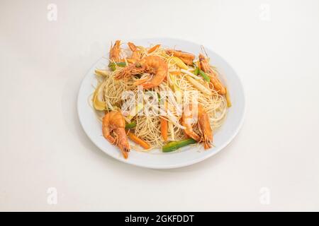 Nouilles de riz chinoises aux crevettes frites, pousses de haricots et légumes sautés au wok sur une assiette blanche Banque D'Images