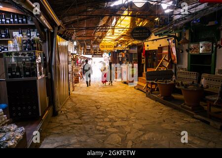 Sirince, Izmir, Turquie - 03.08.2021: Marché local de café de vin et de produits à base de plantes dans le village de Sirince et passage dans l'obscurité et les gens qui marchent autour Banque D'Images