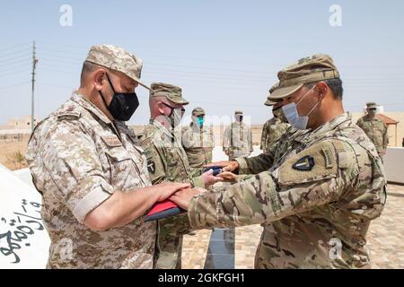 Forces armées jordaniennes, Commandement Sud, 3e commandant du Groupe des gardes-frontières, Col. Ra'ad Al Aamayra, Et la Force opérationnelle Division Spartan tactique- officier de Jordanie responsable, le colonel Christopher Fletcher, échange des drapeaux dans un geste symbolique d'amitié et de partenariat après l'achèvement réussi de l'exercice de tir en direct Desert Warrior 21, le 8 avril 2021. L'exercice a été vu par les officiers généraux du JAF et les hauts dirigeants du centre de l'Armée des États-Unis et de la FO Spartan. Les moments de gratitude exprimée aident à solidifier la relation durable entre les deux forces. Banque D'Images