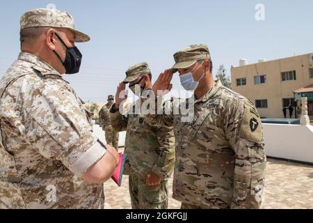 Forces armées jordaniennes, Commandement Sud, 3e commandant du Groupe des gardes-frontières, Col. Ra'ad Al Aamayra, Et l'officier responsable de la division Spartan de la Force opérationnelle tactique- Jordanie, le colonel Christopher Fletcher, reçoit leur drapeau de pays avant d'échanger des drapeaux dans un geste symbolique d'amitié et de partenariat après la réussite de l'exercice de tir en direct Desert Warrior 21, le 8 avril 2021. L'exercice a été vu par les officiers généraux du JAF et les hauts dirigeants du centre de l'Armée des États-Unis et de la FO Spartan. Les moments de gratitude exprimée aident à solidifier la relation durable entre les deux forc Banque D'Images