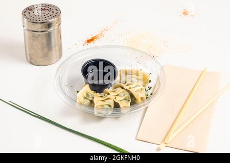 servir de gyozas de légumes avec sauce soja dans un récipient en plastique pour livraison à domicile Banque D'Images