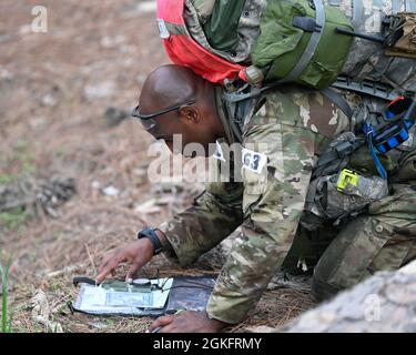 Un candidat des forces spéciales de l'armée américaine John F. Kennedy Special Warfare Center and School utilise un compas, un rapporteur et une carte pour tracer son prochain mouvement pendant l'entraînement à la navigation terrestre pour l'évaluation et la sélection des forces spéciales près de Hoffman, en Caroline du Nord le 10 avril 2021. Les candidats qui ont participé à l'évaluation et à la sélection de trois semaines ont été évalués quant à leur capacité de travailler individuellement et en équipe. Banque D'Images