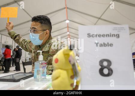 U.S. Air Force Airman 1st Class Francisco Gomez, natif de Miami et technicien en dossiers médicaux, affecté au 335e Air Expeditionary Group, tient une affiche à table ouverte pour recevoir le prochain membre de la communauté au centre de vaccination communautaire pilote de la station de métro Greenbelt, à Greenbelt, Maryland, le 12 avril, 2021. Le Commandement du Nord des États-Unis, par l'intermédiaire de l'Armée du Nord des États-Unis, demeure déterminé à fournir un soutien continu et souple du ministère de la Défense à l'Agence fédérale de gestion des urgences dans le cadre de la réponse pangouvernementale à la COVID-19. Banque D'Images