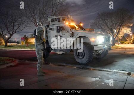 Les soldats de la Garde nationale du Minnesota gardent la garde, renforçant ainsi les forces de l'ordre locales au Brooklyn Center, Minnesota, le 13 avril 2021, la nuit qui a suivi les troubles initiaux dans la région. Plus de 2,000 soldats et aviateurs ont été activés à l'appui de l'opération Safety Net, un effort coordonné visant à protéger les droits des manifestants pacifiques et à assurer la sécurité du public pendant le procès de Derek Chauvin. Les organisations participant à l'opération Safety Net s'engagent à protéger les personnes, les biens et la liberté d'expression.​ Banque D'Images