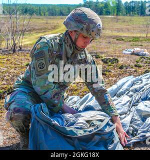 Une femme paratrooper de la 82e division aéroportée emboîte son parachute T-11 dans son sac de récupération parachutiste universel sur la Sicily Drop zone après un saut de l'égalité des femmes à fort Bragg, N.C., le 13 avril 2021. Les soldats ont complété un laissez-passer entièrement féminin pour rendre hommage à la riche histoire des femmes de l'armée américaine. Banque D'Images