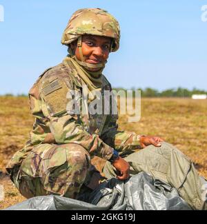 Une femme paratrooper de la 82e division aéroportée détient son parachute T-11 alors qu'elle l'emboîte dans son sac de récupération parachutiste universel sur la Sicily Drop zone après un saut pour l'égalité des femmes à fort Bragg, N.C., le 13 avril 2021. Les soldats ont complété un laissez-passer entièrement féminin pour rendre hommage à la riche histoire des femmes de l'armée américaine. Banque D'Images