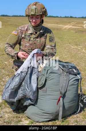 Un parachutiste de la 82e division aéroportée emboîte son parachute T-11 dans son sac de récupération parachutiste universel sur la Sicily Drop zone après un saut pour l'égalité des femmes à fort Bragg, N.C., le 13 avril 2021. Les soldats ont terminé sur un pass entièrement féminin pour rendre hommage à la riche histoire des femmes dans l'armée américaine. Banque D'Images