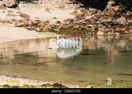 Un bateau en bois rouge et blanc dans Kitchen Porth, Bryher, Isles of Scilly Banque D'Images