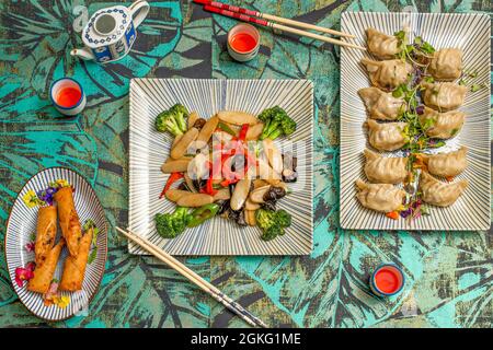 Vue de dessus des plats asiatiques, des petits pains aux crevettes, des gyozas cuits à la vapeur et des pâtes de riz avec des légumes et des champignons shiitake Banque D'Images