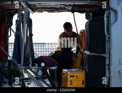 210414-N-RL695-1056 MER DES CARAÏBES - (le 14 avril 2021) -- Aircrewman naval (hélicoptère) de 2e classe Austin Hughes, du lac Stevenson, Washington, affecté aux « Chevaliers de mer » de l'Escadron de combat en mer (HSC) 22, détachement 3, Sangle l'équipement de sauvetage à un réservoir auxiliaire d'un HMH-Seahawk 60S sur la plate-forme de vol du navire de combat littoral Freedom-variant USS Sioux City (LCS 11), le 14 avril 2021. Sioux City est déployée dans la zone d’opérations de la 4e flotte des États-Unis pour appuyer la mission de la Force opérationnelle interagences conjointe Sud, qui comprend des missions de lutte contre le trafic de drogues illicites dans les Caraïbes A. Banque D'Images