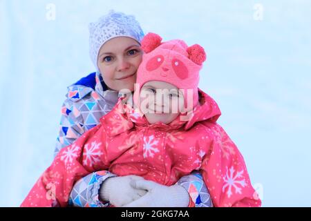 Portrait Maman et fille sont en tubing en hiver. La famille passe du temps dehors en hiver. Jeux de luge. Portrait gros plan. Selfie Banque D'Images