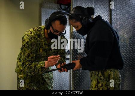 210414-N-BR419-1159 YOKOSUKA, Japon (le 14 avril 2021) Master-at-Arms 1re classe Belisario Salas, de Tri-Cities, Washington, Et Master-at-Arms de 3e classe Katie Chinchen, de Salt Lake City, affecté au seul porte-avions de la marine américaine, le USS Ronald Reagan (CVN 76), ajustent la vue du fusil M4 pour une portée d’armes sur le commandant, Fleet Activities Yokosuka. Ronald Reagan, le navire amiral du Carrier Strike Group 5, fournit une force prête au combat qui protège et défend les États-Unis, ainsi que les intérêts maritimes collectifs de ses alliés et partenaires dans la région Indo-Pacifique. Banque D'Images