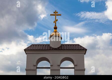 Croix orthodoxe dorée sur fond de ciel nuageux. Banque D'Images