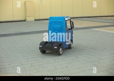 Voiture électrique pour enfants. Un petit camion pour un enfant. Une voiture bleue conduite par un présélectionneur. Banque D'Images