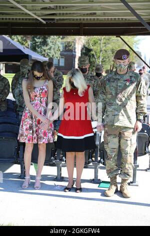 Bang. Le général Curtis Taylor, son épouse Jennifer et sa fille Meredith se sont inclinés devant la tête lors d'une invocation prononcée par l'aumônier de la 5e brigade d'assistance de la Force de sécurité, le Maj. Dom Grotti, lors de la cérémonie de renonciation de la brigade au commandement à Watkins Field, base conjointe Lewis McChord, Washington, le 16 avril 2021. Taylor prend le commandement au Centre national d'entraînement de fort Irwin, en Californie, la semaine prochaine. Banque D'Images