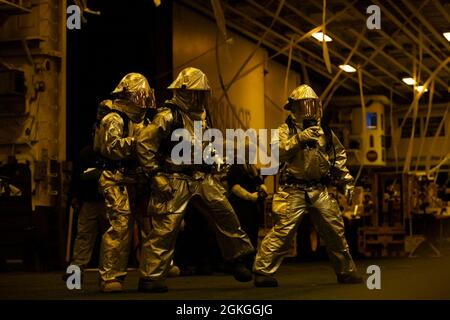 210416-N-MZ836-2099 OCÉAN ATLANTIQUE (le 16 avril 2021) des marins combattent un incendie simulé lors d'un exercice de certification aérienne dans la baie hangar du navire d'assaut amphibie de classe Wasp USS Kearsarge (LHD 3) le 16 avril 2021. Kearsarge, qui a son domicile à la base navale de Norfolk, est en cours de certification pour les opérations en mer. Banque D'Images