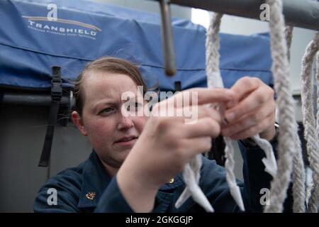 210416-N-WQ732-1109 GOLFE PERSIQUE (le 16 avril 2021) le chef de quartier Amy Birkholz fait l'épi d'un chantier naval à bord du croiseur à missiles guidés USS Monterey (CG61) lors d'un réapprovisionnement en mer dans le golfe Persique, en avril 16. Monterey soutient le groupe IKE Carrier Strike Group lorsqu'il est déployé dans la zone de la 5e flotte des États-Unis et mène des opérations navales pour assurer la stabilité et la sécurité maritimes dans la région centrale, reliant la Méditerranée et le Pacifique à travers l'océan Indien occidental et trois points d'étranglement stratégiques. Banque D'Images