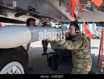 Sergent d'état-major de la Force aérienne des États-Unis Tryton Barnes, membre de l'équipage de chargement du 391e Escadron de chasseurs, aide son équipage de trois hommes à charger un missile Air Intercept dans un F-15E Strike Eagle, le 16 avril 2021, à la base aérienne de Mountain Home, dans l'Idaho. Le concours trimestriel de l'équipage de charge teste la vitesse et les compétences d'un équipage de trois personnes qui charge des munitions dans un avion. Banque D'Images