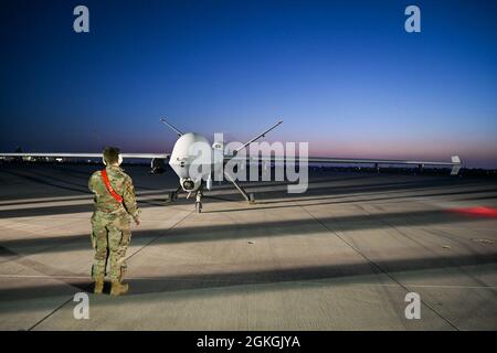 L'avionneur senior Laura Riggs, chef d'équipage adjoint du 49e Escadron de maintenance d'aéronefs, dirige un MQ-9 Reaper pour se garer pendant l'exercice Agile Reaper, le 16 avril 2021, sur la base aérienne navale de point Mugu, en Californie. Tout au long de l'exercice, les aviateurs ont travaillé différents quarts pour exécuter des opérations sur 24 heures afin de tester les capacités de préparation de la MQ-9, dans des conditions de jour et de nuit. Banque D'Images