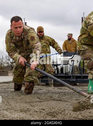 Pennsylvania Air National Guardsman, Tech. Sgt. Lucas Wilkins, affecté au 171e Escadron de génie civil de la Escadre de ravitaillement en carburant, répartit le béton pour s'assurer qu'il n'y a pas de vide ou de poches d'air, le 16 avril 2021. (Pennsylvanie A Banque D'Images