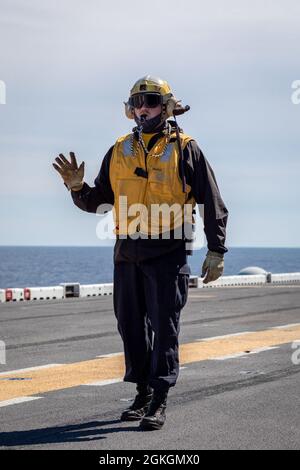 210417-N-MZ836-3018 OCÉAN ATLANTIQUE (le 17 avril 2021) Aviation Boatswain's Mate (Handling) 2e classe Jordan Larson guide un tracteur de remorquage lors d'un exercice de certification aéronautique sur le pont de vol du navire d'assaut amphibie de classe Wasp USS Kearsarge (LHD 3) le 17 avril 2021. Kearsarge, qui a son domicile à la base navale de Norfolk, est en cours de certification pour les opérations en mer. Banque D'Images