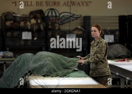 Sgt. Emilee Rolins, une truche de parachute avec l’équipe de soutien du 403e quart de la Garde nationale de Caroline du Nord, déploie un parachute en l’inspectant à fort Bragg, en Caroline du Nord, le 17 avril 2021. Le 403e prend en charge les unités de garde de la Caroline du Nord en fournissant des parachutes de fret et des parachutes personnels pour les opérations aériennes. Banque D'Images