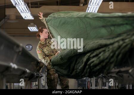 Sgt. Emilee Rolins, une truche de parachute avec l’équipe de soutien du 403e quart de la Garde nationale de Caroline du Nord, déploie un parachute en l’inspectant à fort Bragg, en Caroline du Nord, le 17 avril 2021. Le 403e prend en charge les unités de garde de la Caroline du Nord en fournissant des parachutes de fret et des parachutes personnels pour les opérations aériennes. Banque D'Images