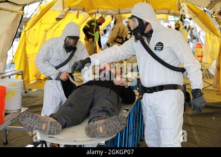 Des soldats de la Compagnie Alpha, 642e Bataillon de soutien de l'aviation de la Garde nationale de l'Armée de New York, pratiquent la décontamination des victimes avec un joueur de rôle civil lors d'un événement d'entraînement collectif de la Force d'intervention de Homeland à East Amherst, New York, le 17 avril. Les solders sont affectés dans le cadre de l'élément de décontamination de la FMA région II HRF, chargée d'intervenir dans les premières heures et les premiers jours des catastrophes naturelles ou causées par l'homme. Banque D'Images