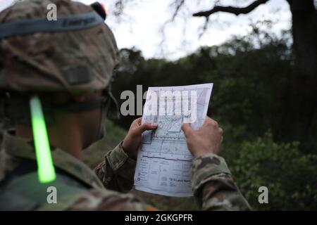 SPC. Karhl Wayman double vérifie sa carte au cours de la nuit de navigation terrestre de la compétition du meilleur guerrier du Commandement de l'Intelligence militaire (MIRC) le 17 avril 2021, à la base conjointe San Antonio – Camp Bullis. Des événements comme la navigation terrestre testent les capacités et la préparation au combat des concurrents et aident à déterminer quel soldat sera nommé meilleur guerrier du MIRC. Banque D'Images