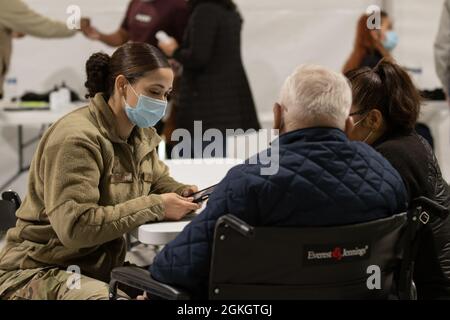 Sergent d'état-major de la Force aérienne des États-Unis Michelle Arthur, une adjointe autochtone et dentaire d'Augusta, en Géorgie, affectée au 335e Groupe expéditionnaire aérien, filtre un membre de la communauté au centre de vaccination communautaire pilote géré par le gouvernement fédéral à Greenbelt, en Maryland, le 18 avril 2021. Le Commandement du Nord des États-Unis, par l'intermédiaire de l'Armée du Nord des États-Unis, demeure déterminé à fournir un soutien continu et souple du ministère de la Défense à l'Agence fédérale de gestion des urgences dans le cadre de la réponse pangouvernementale à la COVID-19. Banque D'Images