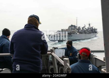 OCÉAN ATLANTIQUE (18 avril 2021) Cmdr. John D. John, au centre à gauche, commandant du destroyer à missiles guidés de la classe Arleigh Burke USS Ross (DDG 71), observe que Ross vient à côté du navire de soutien de combat rapide USNS Supply (T-AOE 6) pour un réapprovisionnement en mer dans l'océan Atlantique, le 18 avril 2021. Ross, déployé vers l'avant à Rota, en Espagne, est en patrouille dans la zone d'opérations de la Sixième flotte des États-Unis pour soutenir les alliés et les partenaires régionaux et les intérêts de sécurité nationale des États-Unis en Europe et en Afrique. Banque D'Images