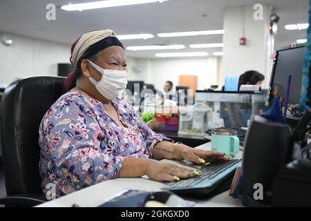 Aki McSwain, la principale agence de voyages du Bureau du transport aérien régulier, travaille à son ordinateur à la base aérienne de Kadena, au Japon, le 19 avril 2021. Le Bureau de gestion de la circulation aide les membres du service en transition en raison d'un changement permanent de poste ou d'une fonction temporaire. Banque D'Images