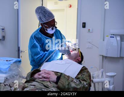 Le senior Airman Sonia Hall, technicien prophylactique du 31e Escadron dentaire, effectue un nettoyage des dents sur un patient à la base aérienne d'Aviano, en Italie, le 20 avril 2021. Hall conserve les cartes d'accident et les chariots d'urgence pour s'assurer qu'ils sont pleins de fournitures et de médicaments et qu'ils sont prêts en tout temps. En février, le 31e DS a participé au mois national de la santé dentaire des enfants, visitant des écoles pour enseigner aux enfants les bienfaits du fluorure et de la bonne santé buccodentaire. Banque D'Images