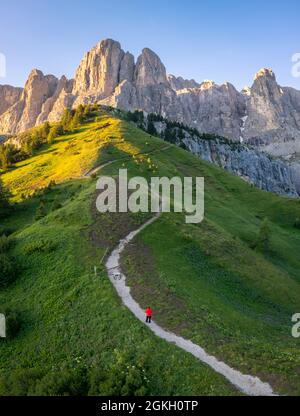 Vue aérienne d'une personne admirant le col Gardena au lever du soleil. Dolomites, Tyrol du Sud, quartier de Bolzano, Italie, Europe. Banque D'Images