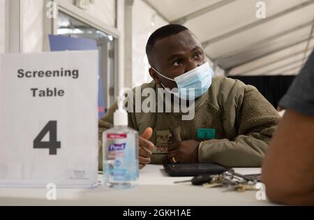 Sergent d'état-major de la Force aérienne des États-Unis Peter Poku, originaire d'Accra, au Ghana, et spécialiste de l'administration médicale affecté au 335e Groupe expéditionnaire aérien, filtre un membre de la communauté au centre de vaccination communautaire pilote géré par le gouvernement fédéral à Greenbelt, au Maryland, le 20 avril 2021. Le Commandement du Nord des États-Unis, par l'intermédiaire de l'Armée du Nord des États-Unis, demeure déterminé à fournir un soutien continu et souple du ministère de la Défense à l'Agence fédérale de gestion des urgences dans le cadre de la réponse pangouvernementale à la COVID-19. Banque D'Images