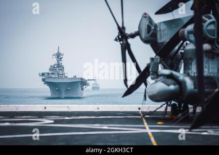 OCÉAN PACIFIQUE (20 avril 2021) le navire d'assaut amphibie USS Essex (LHD 2), à gauche et le destroyer à missile guidé USS Kidd (DDG 100) naviguent en formation derrière le navire de transport amphibie USS Portland (LPD 27), avril 20. Les Marines et les marins de la 11e unité expéditionnaire maritime mènent une formation de routine dans le cadre du Essex Amphiobie Ready Group (ARG). Ensemble, le 11e MEU, l'escadron amphibie (PHIBRON) 1 et les navires sont désignés comme ARG. Banque D'Images