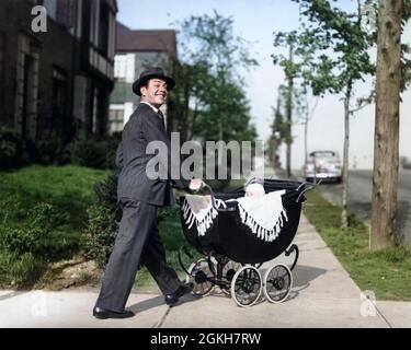 Annees 1940 Annees 1950 Smiling Pere En Fonction Hat Bebe En Poussant Vers Le Bas Du Chariot Trottoir Looking At Camera Photo Stock Alamy