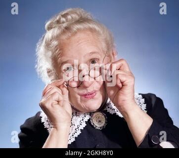 PORTRAIT DES ANNÉES 1950 DE SOURIRE PRISSY OLD GREY HAIR LADY TENANT AJUSTEMENT DE SON ANTIQUE FIL CADRE LUNETTES REGARDANT L'APPAREIL PHOTO OSTENSIBLEMENT - G3529C DEB001 HARS FIL DOUX USURE JOIE ADULTES SATISFACTION FEMMES AÎNÉES STUDIO PORTRAITS ADULTES SANTÉ MAISON VIE DAMES INSPIRATION ADULTE SOIN GRANNY CONFIANCE LUNETTES SENIOR CONTACT OCULAIRE SENIOR FEMME VISION BONHEUR TÊTE ET ÉPAULES PRÉCIEUX LUNETTES EXCITATION SAVOIR FIERTÉ PUSED DANS DES ANTIQUITÉS AUTORITÉ GRANDS-MÈRES PETITS PAINS ANCIENS NOIR ROBE APPROBATION COLS LUNETTES ÉLÉGANT DEB001 GRAND PARENT LES GRANNIES DIFFICILES S'AJUSTENT EXACTEMENT Banque D'Images