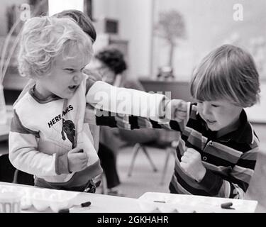 ANNÉES 1970 DEUX GARÇONS EN COLÈRE DE MATERNELLE ÉCOLE MATERNELLE COMBATTANT LE POINÇONNAGE - J14527 HAR001 HARS PROTECTION EN DIFFICULTÉ EXCITATION IRATE FISTS MASCULINE POINÇONNANTE CONCEPTUELLE MÉCONTENTEMENT HOSTILITÉ SOCIALISATION AGRESSIVITÉ AGACEMENT COMPORTEMENT ÉMOTION CROISSANCE ÉMOTIONNELLE IRRITÉ JUVÉNILES SOLUTIONS AGRESSION NOIR ET BLANC CAUCASIEN ETHNIE MÉCONTENT HAR001 OLD FASHIONED Banque D'Images