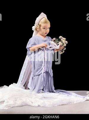 1940 PETITE FILLE BLONDE DANS LA ROBE DE MARIAGE SURDIMENSIONNÉE ET VOILE TENANT LE BOUQUET AVEC L'EXPRESSION CONFUSE REGARDANT LA CAMÉRA - J2866C HAR001 HARS 1 BOUQUET JUVÉNILE MIGNON STYLE BLOND STYLE DE VIE CÉLÉBRATION FEMMES ADULTES COPIE ESPACE PERSONNES ENFANTS CÉRÉMONIE VOILE PLEINE LONGUEUR SURDIMENSIONNÉE CONTACT VISUEL PASSAGE BRIDES BOUQUETS DE L'INCERTAINS HABILLER IMAGINATION RITE DE PASSAGE TIMIDE FLEUR ÉLÉGANTE FILLE COY FLEUR FILLES LES JEUNES ROULENT LES SCEPTIQUES RACE BLANCHE HAR001 OLD FASHIONED Banque D'Images