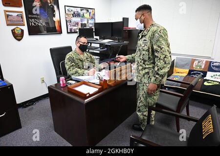 210422-N-BJ295-002 SUNRISE, FL. - (le 22 avril 2021) alors qu'il était recruteur en chef pour la journée, le conseiller en carrière de la Marine 1er classe Demetrius Alford Hands Command Maître-chef Petty Officer (CMDCM) Billy Smith a obtenu l'approbation du recruteur en chef Conseiller en carrière de la Marine Robby Sanders au Groupe d'acquisition de talents de la Marine (NTAG) Miami. Alford a remporté le titre de recruteur principal pour la journée en répondant à des questions cachées autour de son officier dans des oeufs de pâques en plastique. Le défi était ouvert à tous les recruteurs, avec des œufs cachés dans tous les postes de recrutement du NTAG à Miami. Banque D'Images