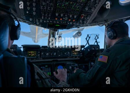 De la gauche, le Maj James Johnson et le capitaine Stephen Tice, tous deux pilotes du 3e Escadron de transport aérien, préparent un C-17 Globemaster III pour un ravitaillement en vol à partir d'un 171e aéronef de ravitaillement en vol KC-135 Stratotanker, affecté à la Garde nationale aérienne de Pennsylvanie, lors d'un vol d'entraînement local au-dessus de l'Ohio, le 22 avril 2021. Le 3e AS s'entraîne pour soutenir l'engagement mondial par la livraison directe des équipements de théâtre critiques et pour assurer la préparation au combat des équipages C-17 du Commandement de la mobilité aérienne. Banque D'Images