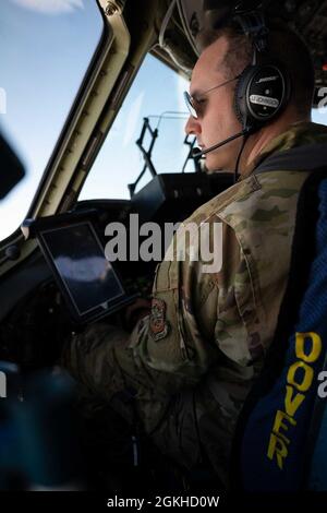 Le Maj James Johnson, pilote du 3e Escadron de transport aérien, regarde la fenêtre du pont de vol d'un C-17 Globemaster III lors d'un vol d'entraînement local au-dessus de la Virginie, le 22 avril 2021. Le 3e AS s'entraîne pour soutenir l'engagement mondial par la livraison directe des équipements de théâtre critiques et pour assurer la préparation au combat des équipages C-17 du Commandement de la mobilité aérienne. Banque D'Images