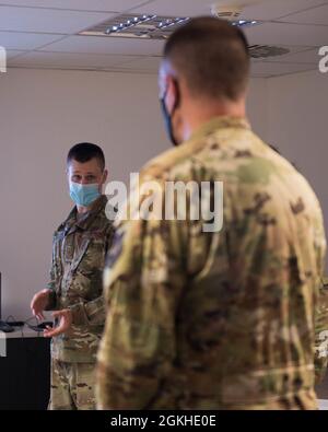 U.S. Air Force Tech. Sgt. Matthew Lauterlein, 86e analyste de gestion de la maintenance du Groupe de maintenance et officier non commandant en charge, à gauche, apprend qu'il est l'aéroglisseur de la semaine du Col. Matt S. Husemann, 86e commandant de l'escadre du transport aérien à la base aérienne de Ramstein, en Allemagne, le 22 avril 2021. Lauterlein, a été sélectionnée à la main pour promouvoir la vision du 86e MXG dans la mise en œuvre du programme Power BI. Banque D'Images