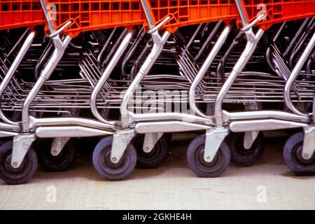 MODÈLE DES ANNÉES 1980 UNE RANGÉE DE CHARIOTS D'ÉPICERIE AVEC DES PANIERS ORANGE POUSSÉS ENSEMBLE EN ATTENDANT QUE LES CLIENTS MAGASINENT - KS19552 AND001 HARS PLAQUÉ SYMBOLIQUE CHROME COMMERCE CONCEPTS ENTREPRISES COMMODITÉ GRAPHIQUE EFFET ANCIENNE REPRÉSENTATION Banque D'Images