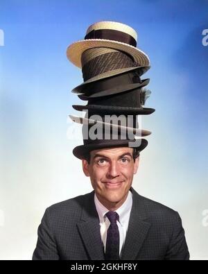 DANS LES ANNÉES 1950, PORTRAIT D'HOMME SOURIANT PERSONNAGE EN COSTUME ET CRAVATE REGARDANT L'APPAREIL PHOTO PORTANT UNE PILE DE SIX CHAPEAUX - P5617C DEB001 HARS COPY SPACE ACHETER SIX B&W EMPILÉS OEIL CONTACT COMPÉTENCE RÊVES BONHEUR COMPÉTENCES TÊTE ET ÉPAULES BIZARRES FUNKY CHOIX DE RÉSEAUTAGE LEADERSHIP ZANY NERDY FIERTÉ NON CONVENTIONNELLE GENS HOMMES PROFESSIONS SOURIT HOMME D'AFFAIRES HOMMES D'AFFAIRES GENS D'AFFAIRES INDÉCISION CONCEPTUELLE PERSONNALITÉ MULTIPLE MULTITÂCHE HOMMES D'AFFAIRES GENS D'AFFAIRES DINGO WACKY DEB001 IDENTITÉS IDIOSYNCRATIE INDÉCIS AMUSANT CRÉATIVITÉ EXCENTRIQUE HABERDASHER HABERDASHERY HOMME MOYEN-ADULTE Banque D'Images