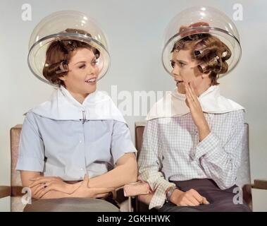 ANNÉES 1960 DEUX FEMMES ASSIS ENSEMBLE GOSSIPING SOUS LE SÈCHE-CHEVEUX DE COIFFURE - S15080C HAR001 HARS GROWNUPS FEMELLES GOSSIP CHALEUR GRONDNUP AMITIÉ DEMI-LONGUEUR DAMES PERSONNES ADULTES PARLER COUPLES FRÈRES ET SŒURS GOSSIPING B&W CURLERS BONHEUR LOISIR RÉSEAUTAGE SIBLING SOURIRES GOSSIPS SÈCHE-CHEVEUX BEAUTÉ SALON ÉLÉGANT EN PLASTIQUE DÔME SALON DE COIFFURE JEUNE FEMME ADULTE NOIR ET BLANC RACE BLANCHE HAR001 OLD FASHIED Banque D'Images