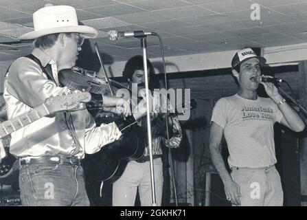 Austin Texas USA, vers 1980 : L'amateur SCOTT WILSON (à droite) chante à The Broken Speak avec le musicien Alvin Crow (jouant du violon). ©Bob Daemmrich Banque D'Images