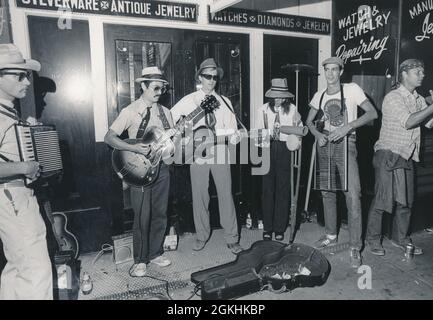 Austin Texas USA, circa 1980 : musiciens jouant pour des conseils sur le trottoir dans le quartier de divertissement East Sixth Street d'Austin. ©Bob Daemmrich Banque D'Images