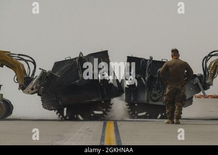 Une scie à béton se coupe dans des sections d'un passage de taxi actif lors d'un événement de formation sur la réparation rapide des dommages sur les champs aériens à la base aérienne d'Al Udeid, au Qatar, le 16 avril 2021. L'événement de formation RADR a mis en évidence la capacité du 379e Escadron de génie civil expéditionnaire de restaurer efficacement un aérodrome endommagé à un état opérationnel aussi rapidement que possible après une attaque. Banque D'Images